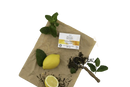 Eine bio-minzseife von mayfie in weiß gold verpackt mit frischer minze und zitronen für natürliche seife im mana shop