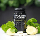 Schwarze flasche supreme digestive enzymes mit weißen kapseln und frischer minze und ingwer zur unterstützung der verdauung und nährstoffaufnahme