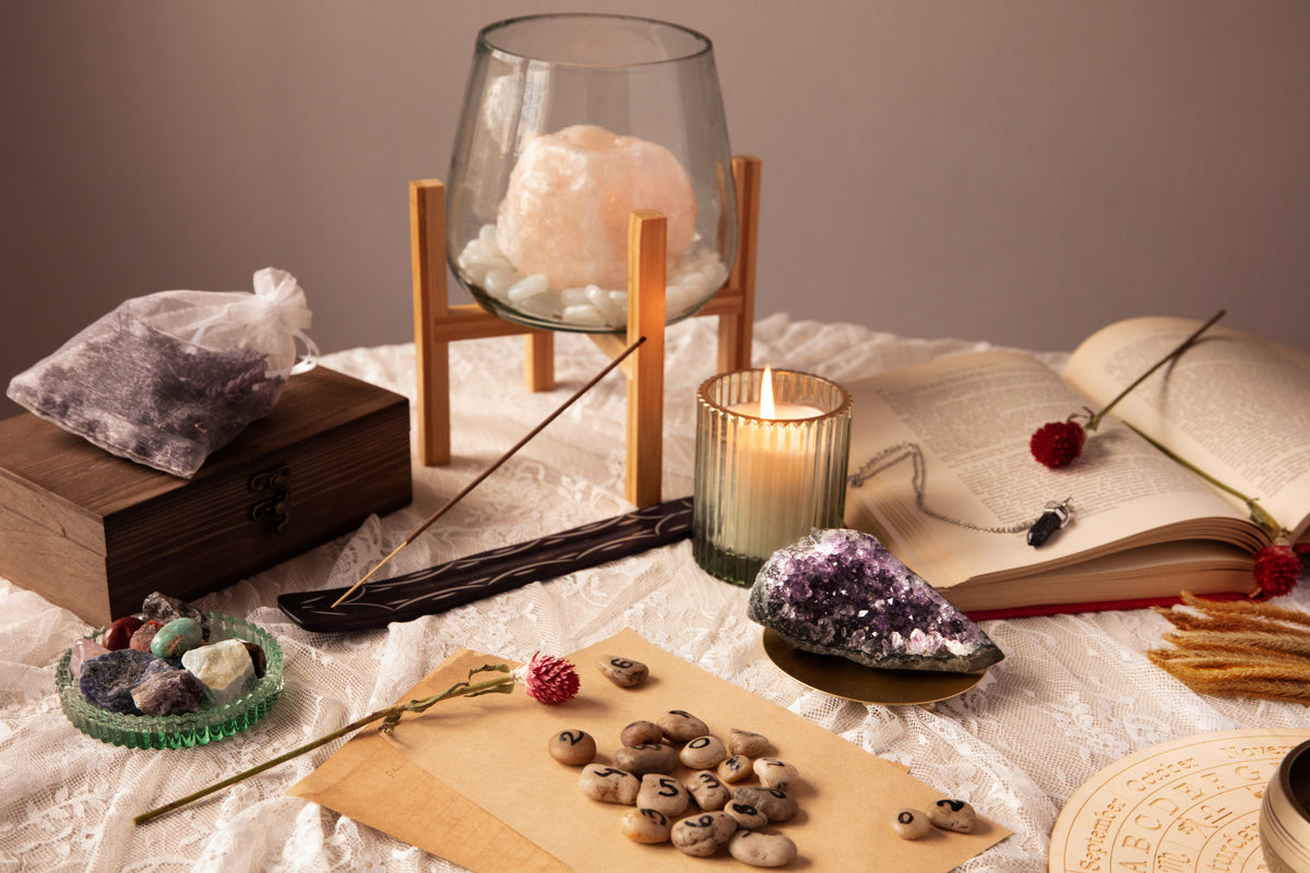 Spirituelle Dekoration mit Amethyst, Rosenquarz-Lampe, Räucherstäbchen und Heilsteinen.