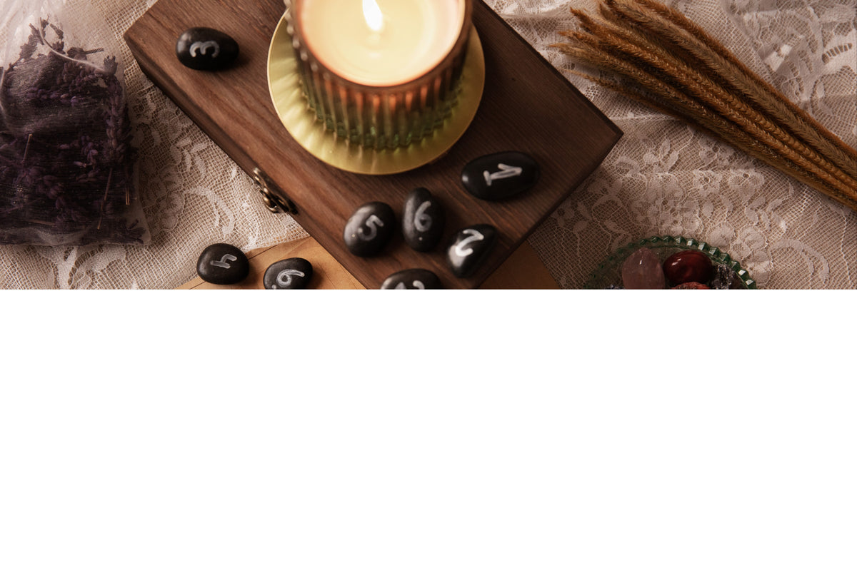 Entspannende Wellness-Atmosphäre mit Duftkerze, Massage-Steinen und Lavendel auf Spitze.