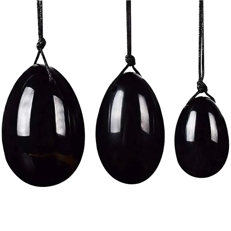 Drei schwarze, glänzende yoni-ei steine aus kraftvollem vulkanglas schwarzer obsidian von artisans de madagascar