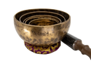 Goldene original tibetische vollmond klangschale mit feiner gravur auf gemustertem lila gold kissen