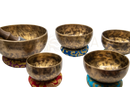 Set aus fünf handgehämmerten original tibetische vollmond klangschalen mit gravierten mustern und bunten kissen