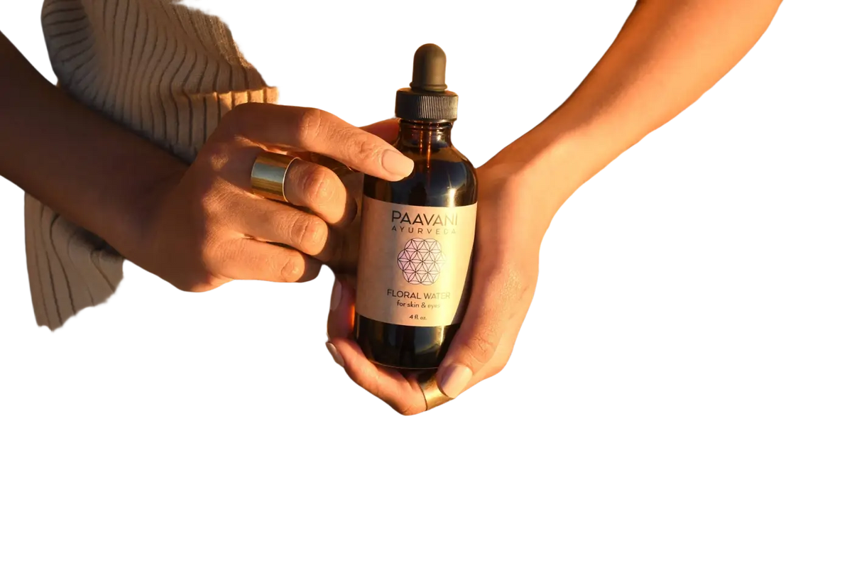 Gesicht mit PAAVANI Ayurveda Blütenwasser, botanische Feuchtigkeitspflege für Haut und Augen, in einer eleganten Flasche.