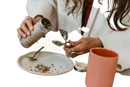 Ein silberner zylindrischer paavani ayurveda gewürzbehälter wird gekippt, um ayurvedischen tee für hormonelles gleichgewicht zu dosieren