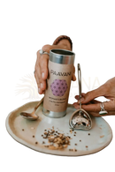 Ein zylindrisches metallic tee tin mit beige papieretikett paavani ayurveda woman’s blend für menstruationsunterstützung