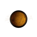 A round dark amber glass jar filled with shimmering golden yellow powder of paavani ayurveda pitta spice blend from mana shop