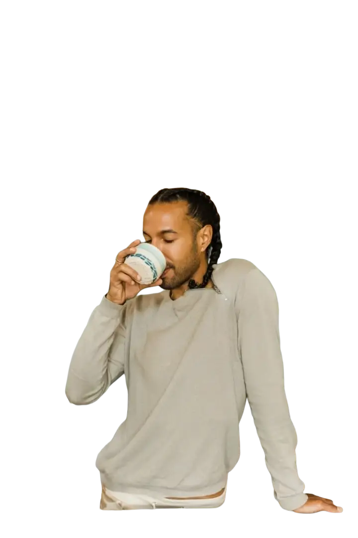 Weiße keramiktasse mit grün-blauem muster am rand neben paavani ayurveda triphala superfrüchtemischung für verdauung und entgiftung