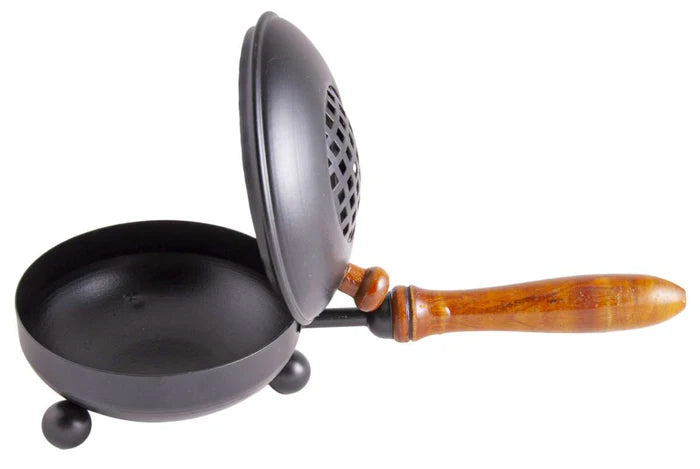 Traditionelle schwarze Pfanne mit Holzgriff und Siebdeckel für die Küche