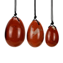 Drei polierte roter japis yoni-ei anhänger in ei-form an schwarzen kordeln von artisans de madagascar für weibliche selbstfürsorge