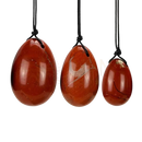 Drei polierte rote jasper yoni-ei anhänger 45 × 35 mm mit bohrung an schwarzen kordeln handgefertigte naturunikate von artisans de madagascar zur weiblichen selbstfürsorge