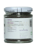 Ein klares glas mit schwarzen senfkörnern für die ayurvedische küche in bewusster gewürzkochkunst