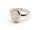 Ein silberner Ring mit glatter Ringschiene und einem großen, ovalen, irisierenden weißen Stein, auf einem weißen Hintergrund.