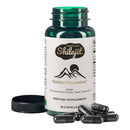 Grüne glasflasche golden mountains shilajit dietary supplement mit weißem etikett und schwarzem berglogo
