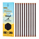 Dunkelbernsteinfarbene honigstäbchen mit 8% shilajit in beutel aus lebendigem gelb und blau für natürliche energie beim mana shop