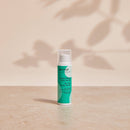 Apeiron Lippenpflege Akut-Lotion auf einer Steinfläche mit sanften Blätterschatten im Hintergrund.