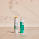 Apeiron Bienenwachs Balsam-Stift und Lippenpflege Akut-Lotion auf einer Steinfläche mit sanften Schatten.