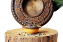 Eine rustikale gelbe keramikschale mit einer grünen tee kräutermischung für menopause relief und hormonelles gleichgewicht auf einem holzstumpf