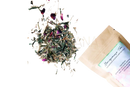 Ein beiger papierbeutel mongeause tea mit grünem und weißem label enthält eine grünteemischung für hormonelles gleichgewicht und menopause relief