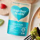 Veganes Kalziumpräparat in 60 Kapseln, Nahrungsergänzung von Together Health, zeigt die Kapseln in einer offenen Packung.
