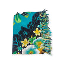 Ein gefalteter türkisfarbener Sarong mit leuchtenden tropischen Hibiskus- und Blattmustern und Fransenrand.