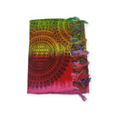 Ein gefalteter regenbogenfarbener Sarong mit Sonnenstrahlen-Mandala-Muster und Fransenrand.