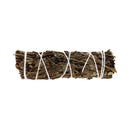 Horizontale Ansicht eines getrockneten Kräuter-Smudge-Sticks, der fest mit weißem Band gebunden ist.