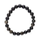 Ein kreisförmiges Perlenarmband aus polierten schwarzen Obsidian-Steinen, von denen einige einen natürlichen goldenen Schimmer aufweisen.