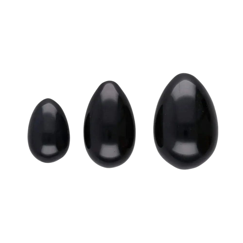 Drei polierte schwarze Yoni-Obsidian-Eier von Vives de la Cortada SCP, Teil der Yoniei Obsidian-Eierpackung, auf weißem Hintergrund