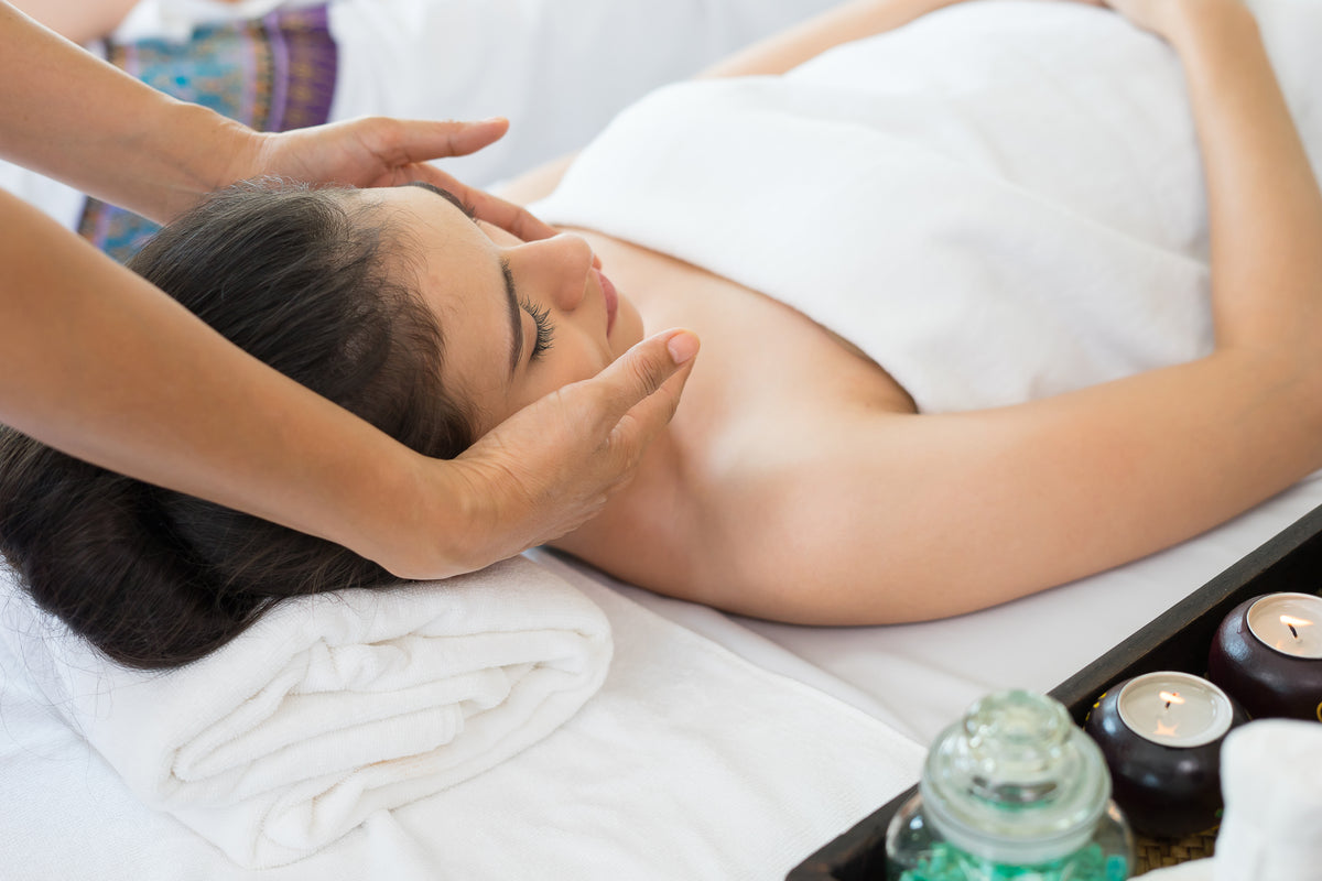 Junge schöne Frau erhält eine entspannende Gesichts-Massage bei Mana Shop, 60 Minuten Therapie für Selbstzahler.