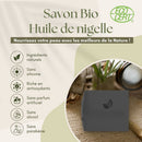 Werbegrafik für Bio-Schwarzkümmelöl-Seife mit einer Liste von Vorteilen auf Französisch.