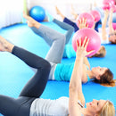 Zwei Yoga- und Pilatesbälle von Zen'Arome in Rosa und Grau, 25 cm Durchmesser, auf weichem Untergrund liegend