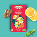 Bio-Kräutertee-Infusion von Zen'Arôme mit Basilikum, Ingwer und Orange, zeigt eine Tasse mit Kräutertee und frische Kräuter.