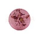 Ein runder rosa badebombe mit getrockneten rosenblättern und violetter pulver für zen-duschdampfbäder tranquility tempest