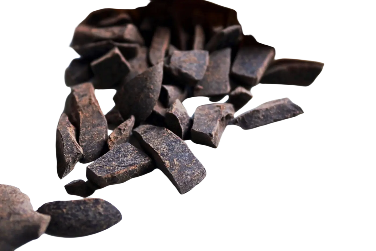 Dark chocolate chunks spilling from a paper bag of zeremonieller roher kakao 100% criollo roher kakao 50g